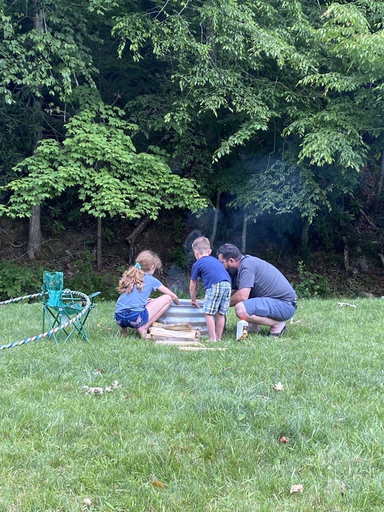 kids making fire with dad